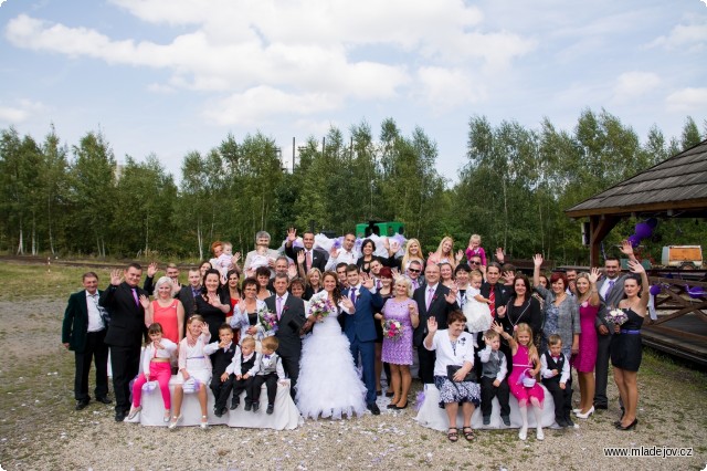 Fotografie Skupinové foto účastníků s&nbsp;komíny mladějovských pecí v&nbsp;pozadí.
