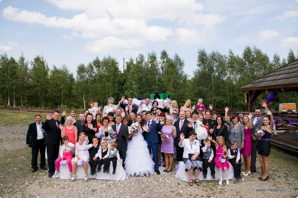 Fotografie Skupinové foto účastníků s&nbsp;komíny mladějovských pecí v&nbsp;pozadí.