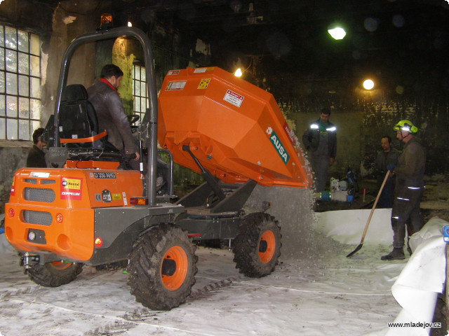 Fotografie Pod štěrkem je ještě pořádná geotextilie a pod ní zlepšená zemina. Adam za volantem zaváží štěrk před kanál.