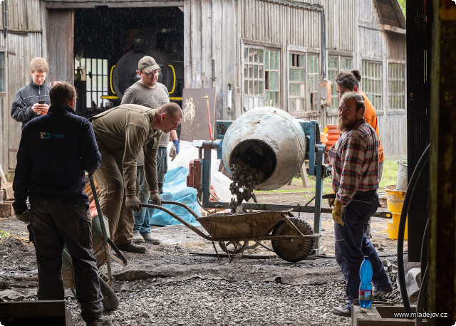 Fotografie Překlopením míchačky na druhou stranu lejeme do koleček, se kterými už netrpělivě čeká parta závozníků.
