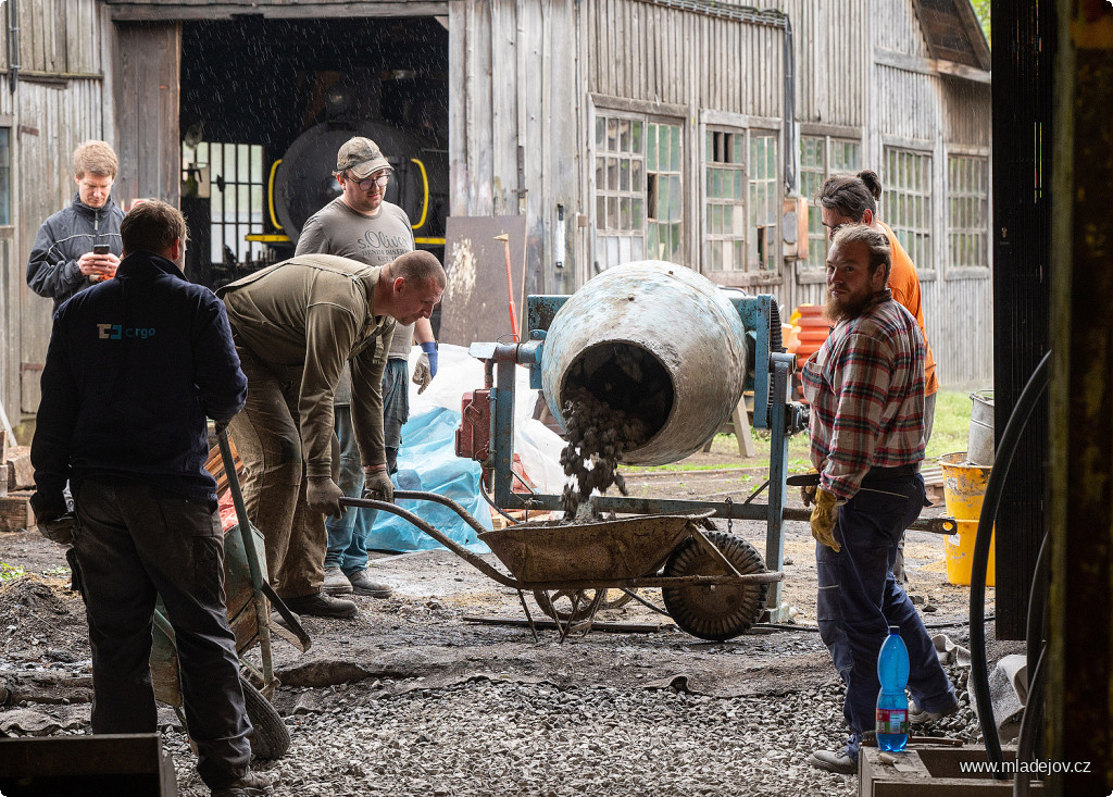 Fotografie Překlopením míchačky na druhou stranu lejeme do koleček, se kterými už netrpělivě čeká parta závozníků.