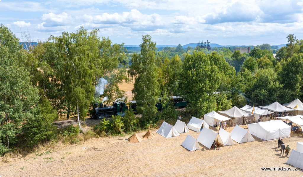 Fotografie Parní vláček se proplétá vojenským ležením směrem na Veksl.